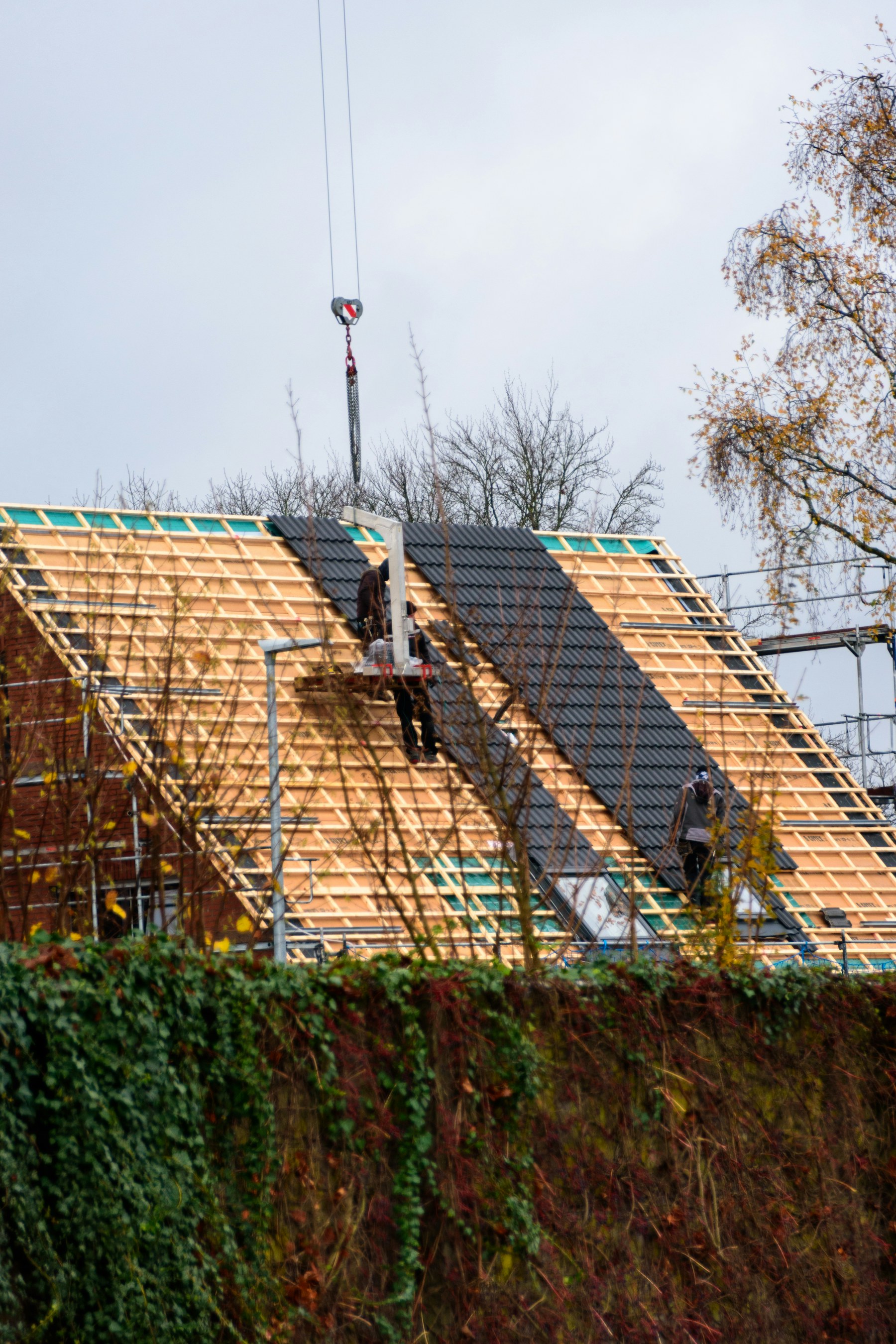 Workers installing tiles on a roof